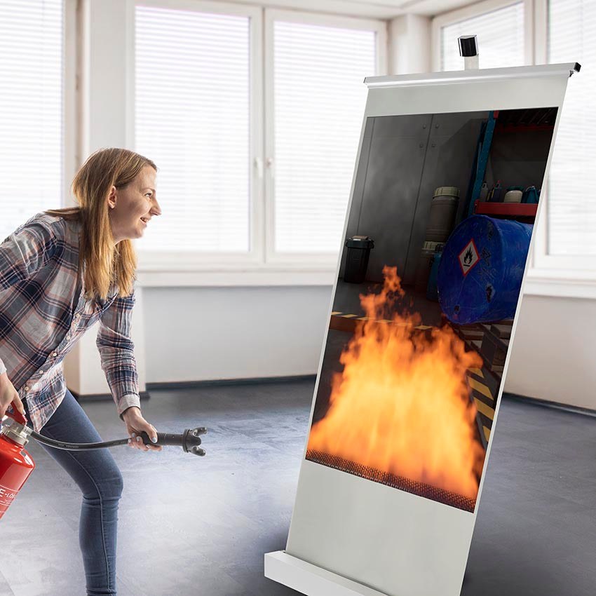 Eine Person löscht einen Flüssigkeitsbrand am AISCO IndoorTrainer M für digitale Brandsimulationen