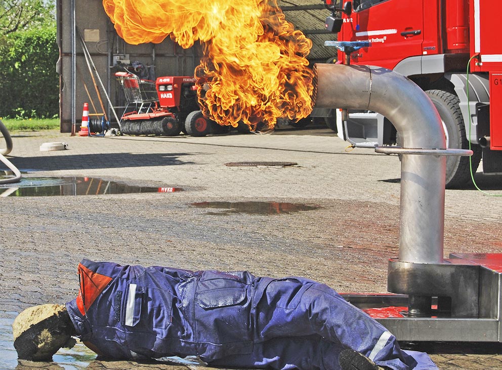 AISCO Fireman neben brennendem AISCO FireTrainer bei Feuerwehr-Einsatzübung